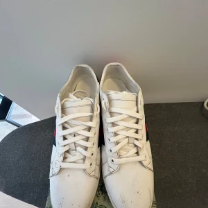 Gucci Ace vita sneakers med metallic-detaljer - Säljer mina skor då dom ej kommer till användning och känner att dom bara sitter o samlar damm. Pris kan diskuteras vid snabb affär 