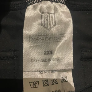 Svarta ridbyxor Maya Delorez XXS - Svarta ridbyxor från Maya Delorez i storlek XXS. Byxorna har helskoning med silikonmönster för extra grepp, bälteshällor och praktiska fickor. Snygg logga på fickan och diskret design som passar perfekt till ridning. Använda fåtal gånger. Nypris 1200 kr 