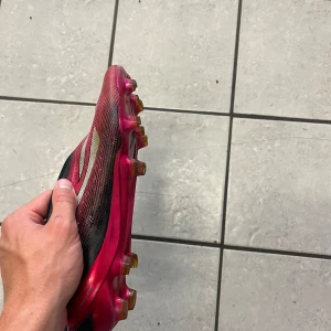 fotbollsskor - Säljer ett par Adidas fotbollsskor i svart och rosa. Skorna är i bra skick dubbarna är knappt slitna 