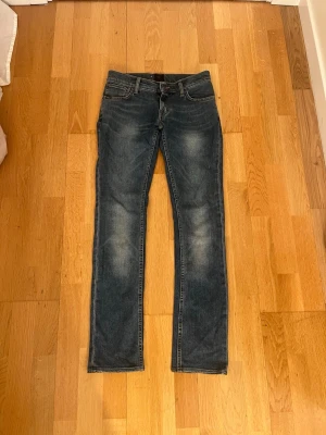 Tiger of Sweden blå jeans storlek 26/32 - Snygga blå jeans från Tiger of Sweden, modell Skogsberg. Klassisk femficksdesign med raka ben och normal passform.Perfekt för dig som gillar stilrena och tidlösa jeans. Storlek 26/32