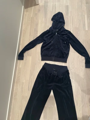  Juicy Couture set - Mörkblått Juicy Couture sett  med bred resår och snörning i midjan. Byxorna har raka ben och bakfickor med knappar. Perfekta för en chill och trendig look.