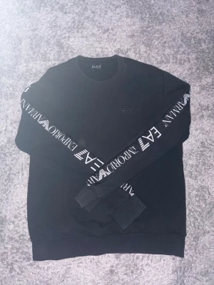 Ea7 sweater i svart - Ea7 sweater i svart med logans tätt runt ärmarna i Size S funkar som M också, inget är fel med tröjan inga hål eller något 