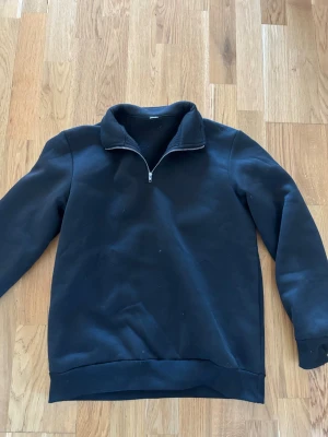 Svart fleece-tröja med half zip - Svart långärmad fleece-tröja med halv dragkedja vid kragen. No brand. Passar om du är 160-170 Storlek XS passar också Xxs