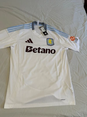 Aston Villa 24/25 borta tröja - Hej! Jag säljer helt ny Aston Villa tröja lappen sitter kvar! Jag fick tröjan i julklapp och säljer den för att den är stor för mig, storleken är M. Ny pris 1099 hör av dig vid funderingar!!