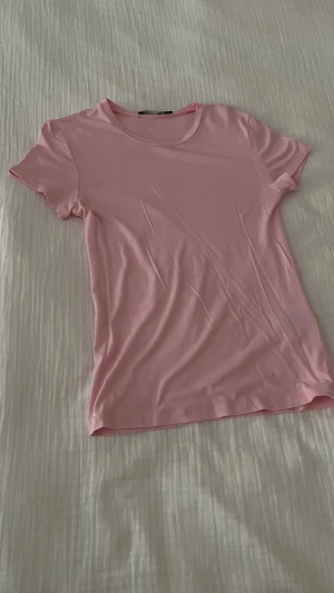 Ljusrosa t-shirt från 157 - Säljer en ljusrosa t-shirt från 157 i storlek S. T-shirten har rund hals och korta ärmar, med en clean och enkel design utan mönster. Materialet är mjukt och känns som bomull, perfekt för chill dagar. Passformen är normal och färgen är riktigt söt.