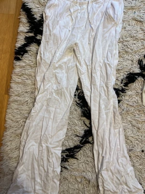 Vita linnebyxor från 157 XS - Säljer ett par vita linnebyxor från 157 i storlek XS. Byxorna har elastisk midja med snörning och är tillverkade i ett lätt och luftigt linnematerial. Skrynkliga och eftersom jag inte strykt de. 