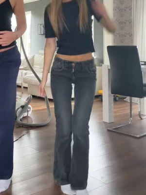 Lågmidjade Svarta bootcut jeans med paljettdetaljer - Snygga svarta jeans med bootcut-snitt och låg midja. Baktill finns fickor med paljettdetaljer. Storlek 158 från Gina Young. Använda 1 gång därav superbra skick. Finns resorband på insidan av midjan. Passar mig bra som är ca 162cm. Köpa för 400kr.