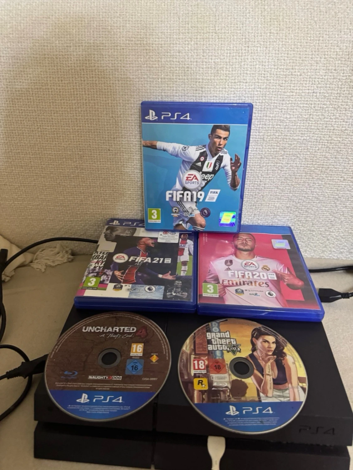 PlayStation 4 Slim och en vanlig playstation 4 med en handkontroll och spel - 1