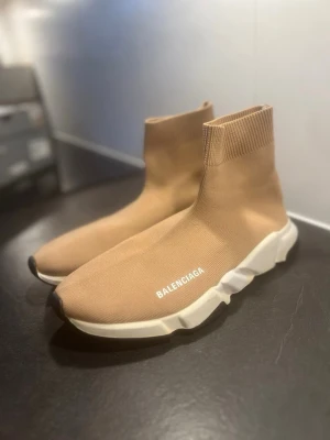 Balenciaga - Säljer ett par beige Balenciaga Speed sneakers med stickad ovandel och vit chunky sula, Perfekt för dig som gillar clean och modern stil skorna är 44 men mer som 43