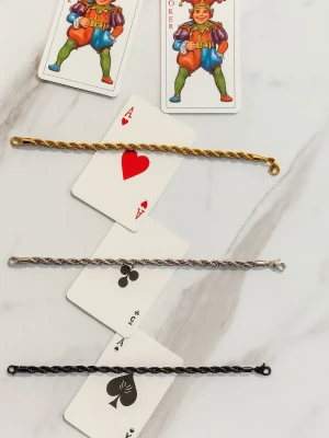 Stilrena flätade armband i guld, silver och svart - flätade armband i guld, silver och svart. Armbanden har en tvinnad design och olika färger, men ingen information om väst kan ges.