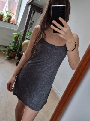 Grey-Silver glittery short dress - Grey-Silvery short dress with silvery glitter (not itchy from the glitter thread - I am myself VERY sensitive). Adjustable straps. Fits approx. S-L. No signs of use. Length: 78 cm (strap to bottom). Says Euro 40/M on the tag.