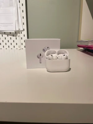 AirPods Pro 3 - Snygga och moderna Apple AirPods Pro 3 med laddningsetui och extra öronkuddar. Komplett med originalförpackning och tillbehör. Trådlös anslutning, aktiv brusreducering och USB-C laddning. Kommer med garanti till 9 oktober 2026