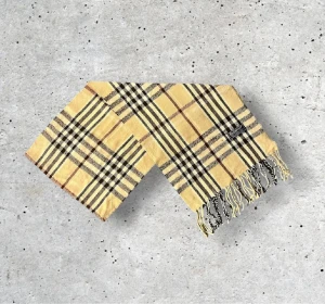Beige Burberry scarf - Säljer en snygg Burberry halsduk i den klassiska beige färgen med det välkända rutmönstret. Tillverkad i 100% mjuk och värmande ull.   🧵 Skick: Mycket fint skick, väl omhändertagen 🌟 Känsla: Mjuk, varm och följsam 📦 Frakt: Skickas tryggt inom 24h 📏 Mått: Längd-175cm, Bredd-35cm Pris kan diskuteras!
