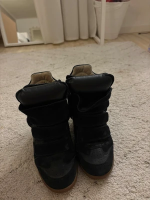 Isabel Marant svarta sneakers med kilklack - Svarta sneakers från Isabel Marant med kilklack, tillverkade i mocka och skinn. Storlek 36 i mycket bra skick! Modell Bekett