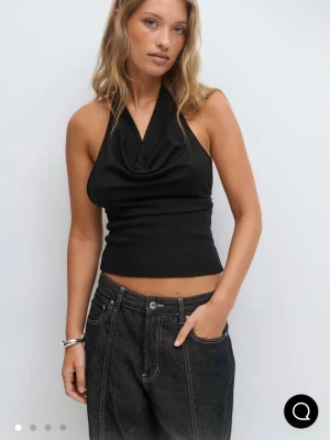 Svart halterneck topp - Svart halternecktopp med öppen rygg från Gina Tricot. Helt ny med prislapp. Slutsåld på hemsidan.