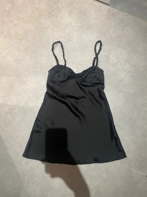 Zara klänning - Kort svart klänning ifrån Zara i storlek M men skulle säga att den sitter som en S jag är 172 cm lång och bör storlek S. Man kan även använda detta som ett snyggt nattlinne! Ser ut som ny då den enbart är använd en gång! 