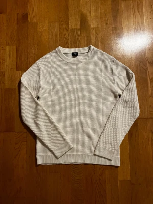 Vit stickad tröja  - Säljer en vit stickad tröja från H&M med snyggt strukturerat mönster. Tröjan har rund halsringning och långa ärmar med ribbade muddar. Perfekt för dig som gillar enkel och stilren design med lite textur. Hör av dig vid funderingar! Mvh Carl
