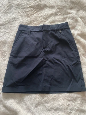 Mörkblå kortkjol Peak Performance - Snygg mörkblå kortkjol från Peak Performance i modellen Illusion Skirt. Som ny!