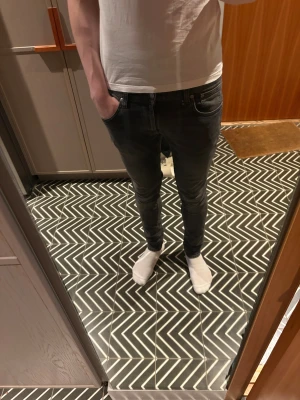 Gråa Tight terry från Nudie  - Säljer ett par gråa skinny jeans från Nudie med klassisk femficksdesign och diskret tvättad look. Jeansen har smal passform, normal midja och är gjorda i stretchigt denim för extra komfort. Snygga detaljer på bakfickorna och dragkedja i gylfen.