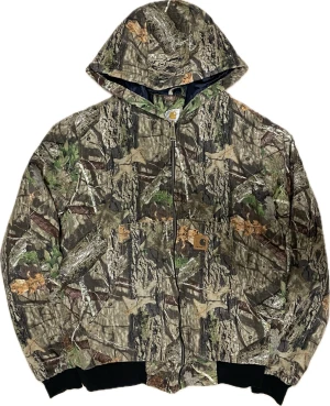 Camo jacka från Carhartt - Vintage Camo Carhartt bomber-ish jacka som håller värmen bra under vintern. Har två innerfickor utöver de två fickorna där fram. Sitter lite ”croppat”.