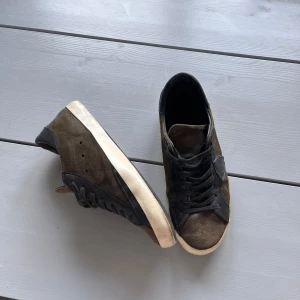 Bruna Philippe Model sneakers i mocka - Snygga bruna sneakers från Philippe Model i mocka med svarta detaljer och vit sula. Klassisk låg modell med snörning och rund tå. Perfekta för dig som gillar stilrena och exklusiva sneakers! Använda och släppt lite i hälen men inget illa. Vid funderingar är det bara höra av sig!.. Våga buda