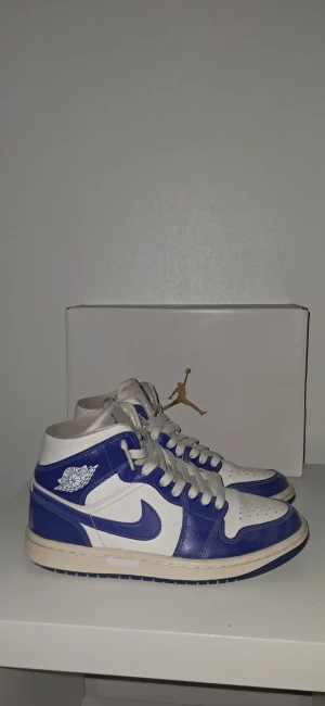 Jordan 1 kentucky  - Nike Air Jordan 1 Mid kentucky i blått och vitt. De är väldigt bra skick då jag inte använt de allt för mycket och dessutom tagit bra hand om de. Skolådan fås med, de är storlek 37.5.