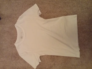 Vit ribbad t-shirt i bomull, M - En basic vit t-shirt i ribbad bomull med rund hals och korta ärmar. Enkel och clean design som passar till allt. Skön passform och mjukt material, perfekt för en chill look.