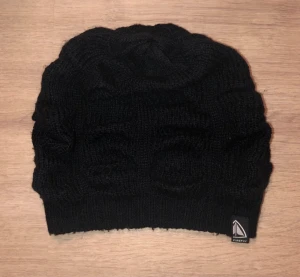 Svart stickad mössa från Firefly - Svart stickad mössa från Firefly med mönstrad struktur. Diskret logga på kanten 