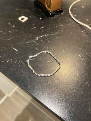 Silver Armband rostfritt stål - Snyggt armband i silverfärg med flätad design. Perfekt för dig som gillar stilrena och enkla smycken med lite twist. Lätt att matcha med andra accessoarer och har ett smidigt lås.