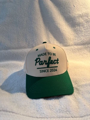 Golf keps  - Snygg keps i beige och mörkgrönt med broderad text från Parfect. Passar perfekt för vardaglig look eller på golfbanan! Hör av er vid fler frågor. 