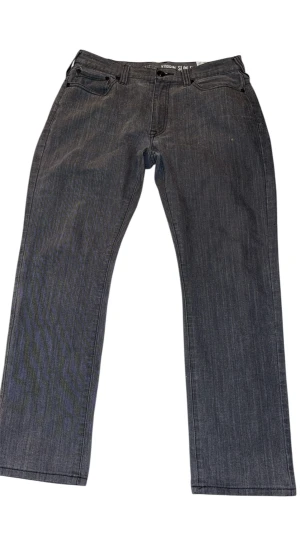 Grå Korbin Slim Fit jeans - Snygga grå jeans från Korbin i slim fit-modell. Klassisk femficksdesign med svarta detaljer och coola sömmar på bakfickorna. Jeansen har rak passform och är tillverkade i mjukt denimtyg som sitter skönt hela dagen.