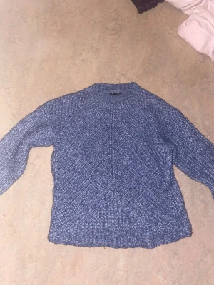 Blå stickad tröja Massimo Dutti - Säljer en blå stickad tröja från Massimo Dutti, tillverkad av italienskt garn. Tröjan har en grovstickad struktur, rund hals och långa ärmar. Perfekt för dig som gillar en chill och snygg look med lite extra textur.