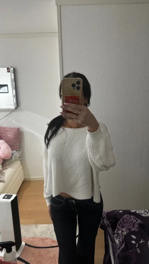 Vit ribbad stickad tröja croppad - Säljer en vit stickad tröja med ribbad struktur och croppad passform. Tröjan har rund halsringning och långa ärmar med lätt ballongeffekt. Perfekt för dig som gillar en chill och stilren look. Passar till både jeans och kjol.