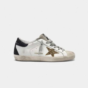 Golden Goose sneakers  - Snygga vita sneakers från Golden Goose med grå snörning, svart glitter på hälen och en glittrig guldstjärna på sidan. Säljer de för de är stora för mig 