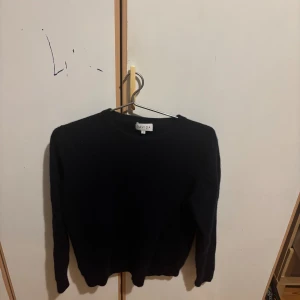 Mörkblå kashmirtröja från Davida 100% cashmere - Säljer en mörkblå, mjuk och stilren kashmirtröja från Davida i storlek S. Den krympte i tvätten så blev mycket mindre. Tröjan har rund hals och långa ärmar, perfekt för dig som gillar klassisk och enkel design med lyxig känsla. Passar dig som vill ha en skön och snygg tröja till hösten och vintern.