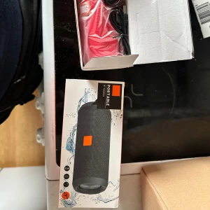 T&G Portable BT Speaker Portabel Bluetooth Högtalare - Ny T&G Portable Bluetooth-högtalare i röd färg, levereras med laddningskabel och manual. Stereoljud, stänkskyddad, upp till 3-4 timmars speltid och inbyggd mikrofon för handsfree-samtal. Produkten är helt ny i originalförpackning utan synligt slitage.Säljer en portabel Bluetooth högtalare. Den är röd och kommer i sin originalförpackning. Perfekt för att lyssna på musik var du än är. Speltid: 3-4 timmar. Med MIC för handsfree telefonsamtal.