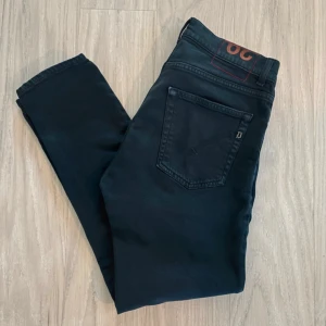 Dondup jeans - Svarta jeans från dondup slim fit, klassisk femficksdesign och smal passform. Jeansen har en snygg mörk ton och är tillverkade i stretchig bomull för extra komfort. Perfekta för dig som gillar en modern och stilren look. Modellen är Dian, är som George 