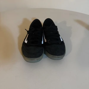 Svarta Vans A.V.E. sneakers - Säljer ett par svarta Vans A.V.E. sneakers med vit sidorand och genomskinlig sula. Skorna har snörning och är tillverkade i mocka och syntet. Klassisk Vans Off The Wall-detalj på hälen och A.V.E.-logga bak. Perfekta för dig som gillar streetstyle.