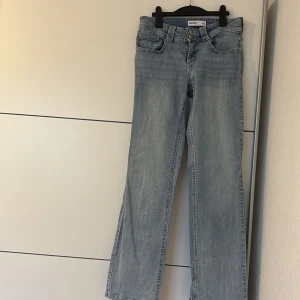 Ljusblå raka jeans från Cropp, M - Snygga ljusblå jeans från Cropp i rak modell med klassisk femficksdesign och dubbla knappar i midjan. Jeansen har en normal passform och är tillverkade i mjukt denimtyg som ger en avslappnad vibe. Perfekta för dig som gillar enkel och stilren look.