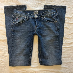 Lågmidjade bootcut jeans  - Ett par blå bootcut jeans med låg midja. Innerbenslängd 79cm, midjemått rakt över 36cm. 