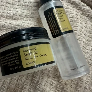 COSRX Snail 92 Cream & Snail 96 Essence - Säljer två populära produkter från COSRX: Advanced Snail 92 All in One Cream (100g) och Advanced Snail 96 Mucin Power Essence (100ml). Krämen är använd med mycket kvar mer än hälften kvar (använt med en applikatorn, ej använt händerna i den) Serumet är de lite mindre en hälften kvar