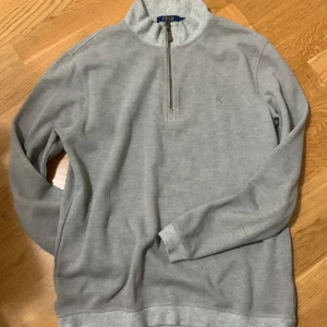Grå half zip tröja Polo Ralph Lauren - Dem är använd 1-3 gånger max och används inte längre då den säljs. Den är i väldigt bra skick utan defekter och vid snabb affär får du ett bra pris!