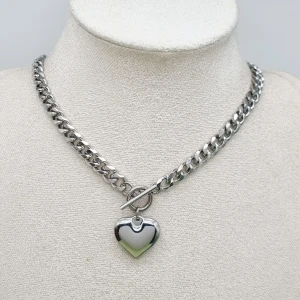 Handgjort halsband med hjärthänge  - Stilrent chunky halsband i silverfärgad metall med ett blankt hjärthänge. Material-rostfritt stål 