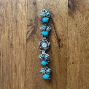 Vintage armbandsur med turkosa stenar - Jättevackert silvrigt armbandsur med turkosa stenar. Klockan fungerar inte just nu men går säkert att fixa i en klock affär, annars är det ändå ett väldigt vackert smycke. 