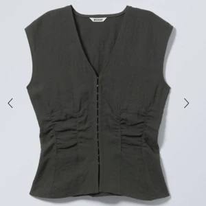 Mörkgrå topp från Weekday - Mörkgrå topp från Weekday med v-ringning och knäppning framtill. Toppen är ärmlös och har lätt rynkade detaljer vid sidorna för en snygg passform. 🩷