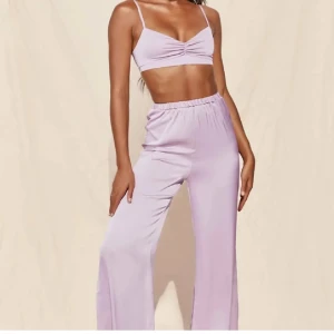 Ljusrosa bikini från Oh Polly - Supersnygg ljusrosa bikini från Oh Polly med glansigt satinliknande material. Toppen har smala axelband och en liten twist-detalj framtill. Bikinitrosan har hög midja och mjuk resår. Perfekt för sommarens strandhäng!