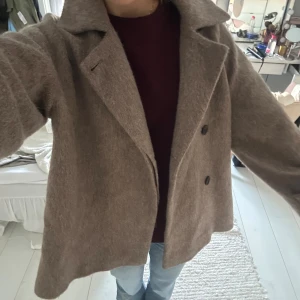 Beige ullkappa från ARKET, strl 34 - Säljer en snygg beige kappa från ARKET i storlek 34. Jackan är i ullblandning, har dubbelknäppning, bred krage och en loose fit. Perfekt för höst och vinter, riktigt trendig och mysig med sin borstade yta och klassiska look. Kan gå ner i pris vid snabb affär