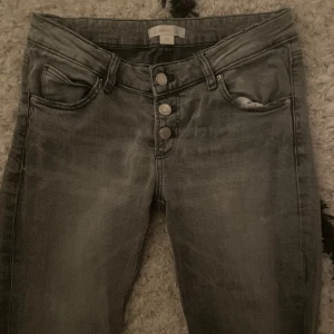 Grå bootcut jeans med knappar - Snygga grå jeans med bootcut-modell och flera knappar i gylfen. Jag har inte andvänd dom så mycke så jag säljer pga att dom inte kommer till andvändning och är lite för långa skriv gärna vid funderingar💗