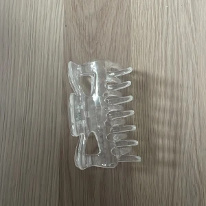 Genomskinlig klämma - Stilren och enkel transparent hårklämma i plast med klassisk form och stark fjäder. Perfekt för att snabbt sätta upp håret och passar till alla hårtyper. Ger en clean look och är lätt att matcha med olika outfits.