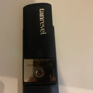 Tanrevel face mist-apparat svart - Säljer en svart face mist-apparat från Tanrevel. Den är smidig och portabel, perfekt för att fräscha upp huden med en jämn mist. Stilren design i svart plast med silvriga detaljer. Laddas enkelt via USB.